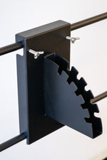 Metal bracket with a serrated edge on a white background. Terra Grills pin attachment system for height adjustment of cooking accessories