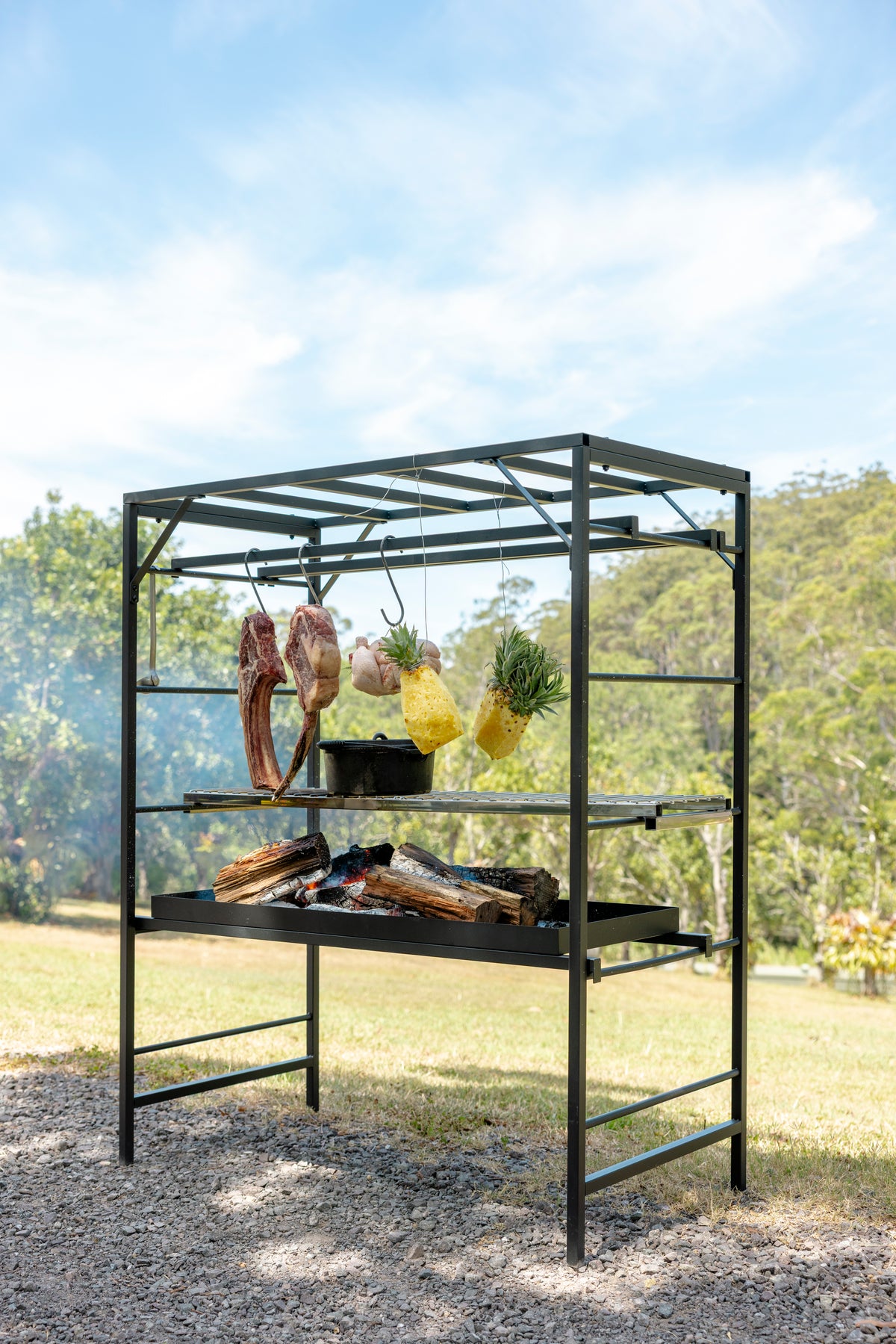 Outdoor barbecue grill with shelves against a natural background. Portico Small outdoor grill in backyard setting with space-efficient design